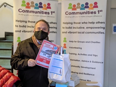 Leader of the Council, Cllr Morris Bright MBE, with the Arsenal Christmas holiday pack included in the parcel